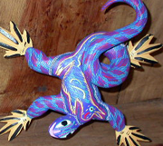 An alebrije of a lizard set up against a wall