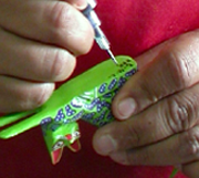 local artist painting details on alebrijes using a very fine tip pen