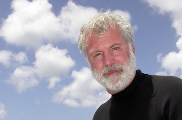 Dr. Bill Gerwick in Curacao with blue sky and white clouds behind him